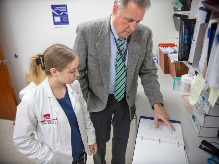 A student and rotation mentor analyze data paperwork